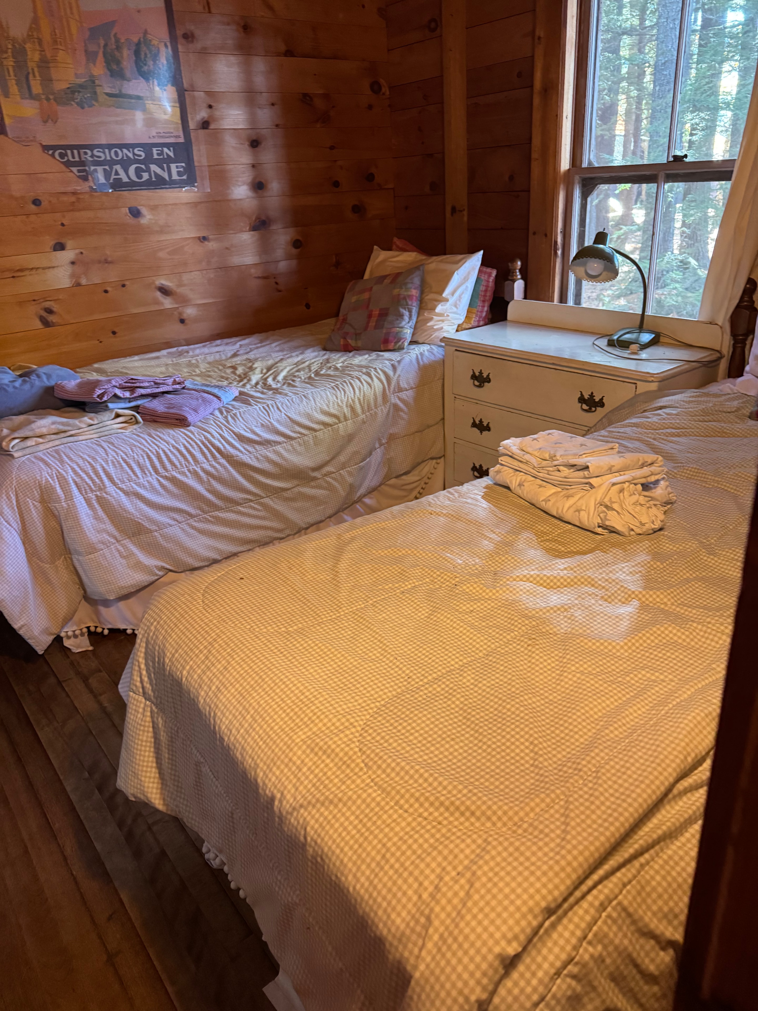 Lake camp bedroom before staging — unmade bed with cluttered surfaces
