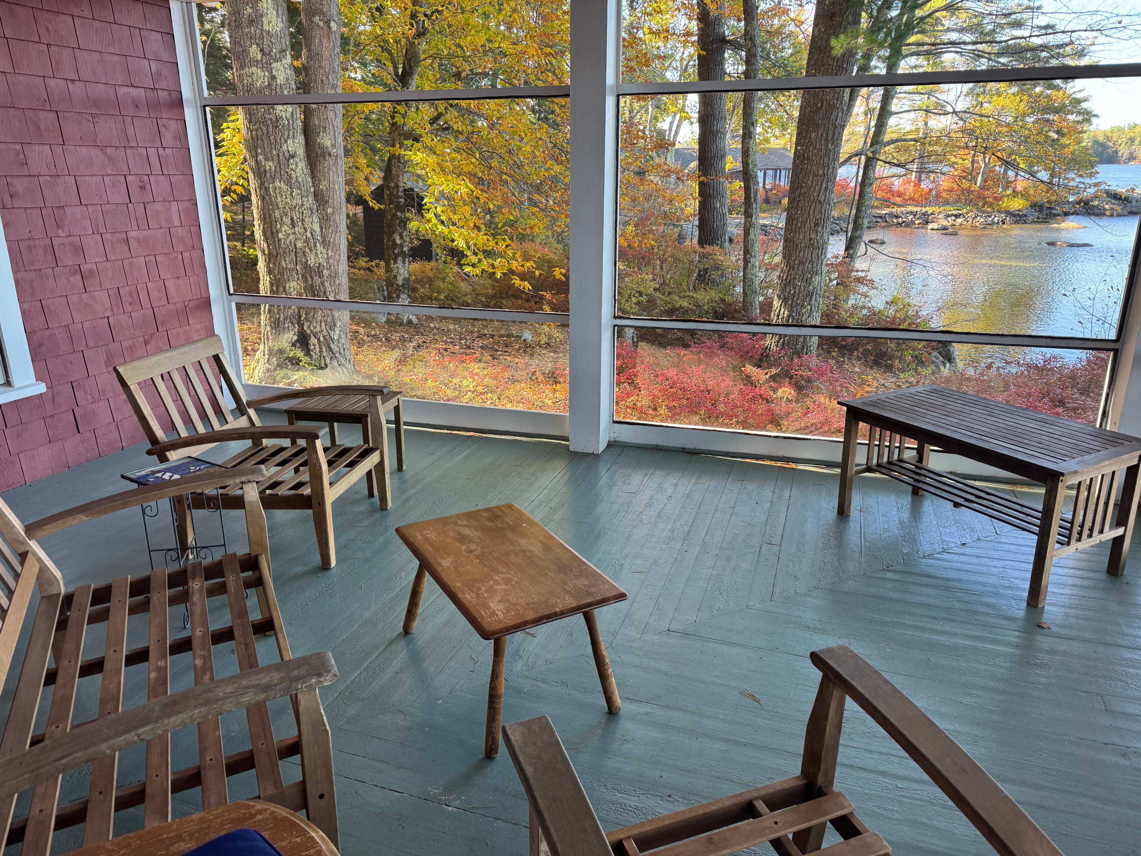 Lake camp porch before staging — screened porch with mismatched chairs