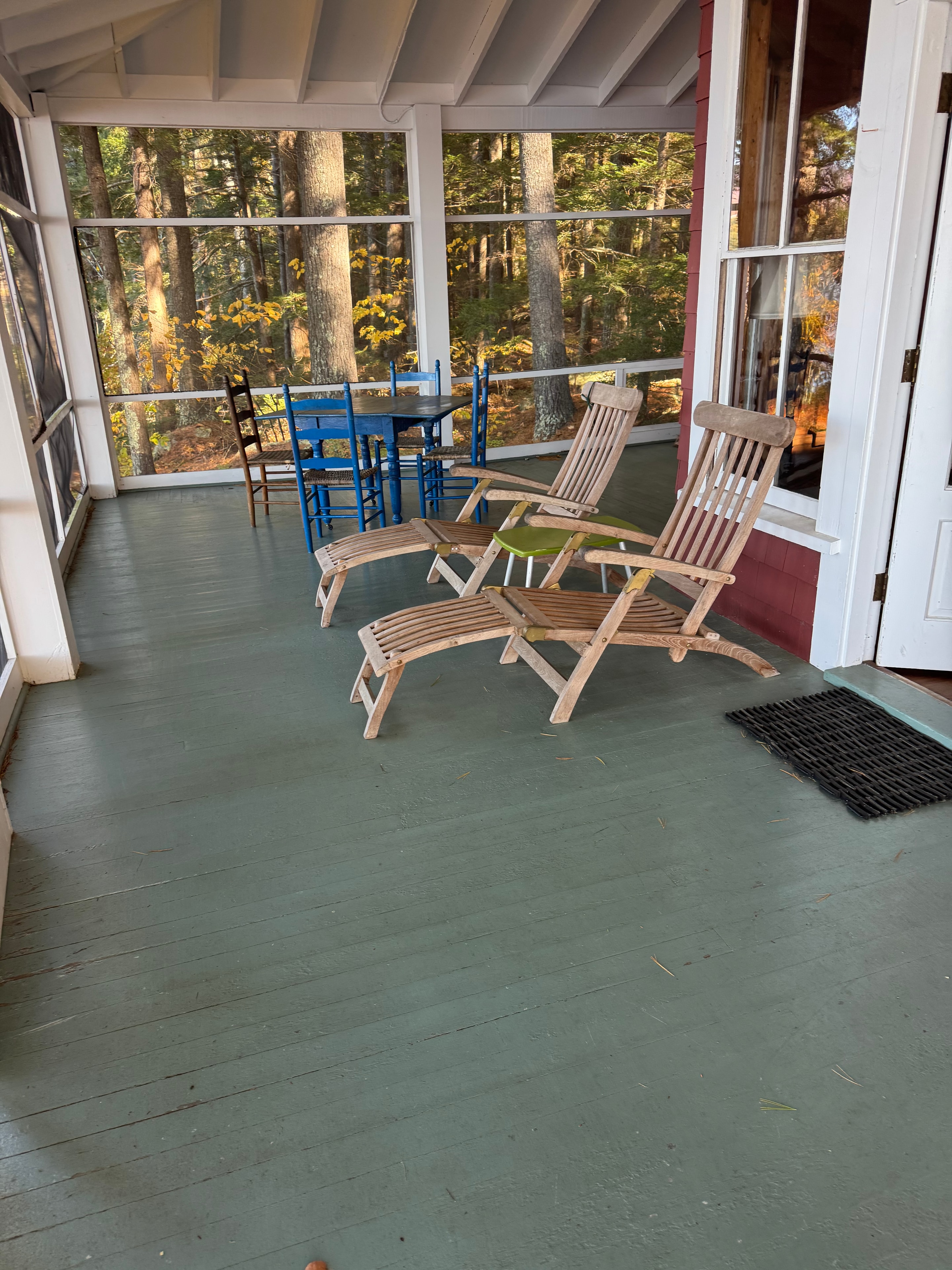 Lake camp porch before staging — screened porch with wooden chairs