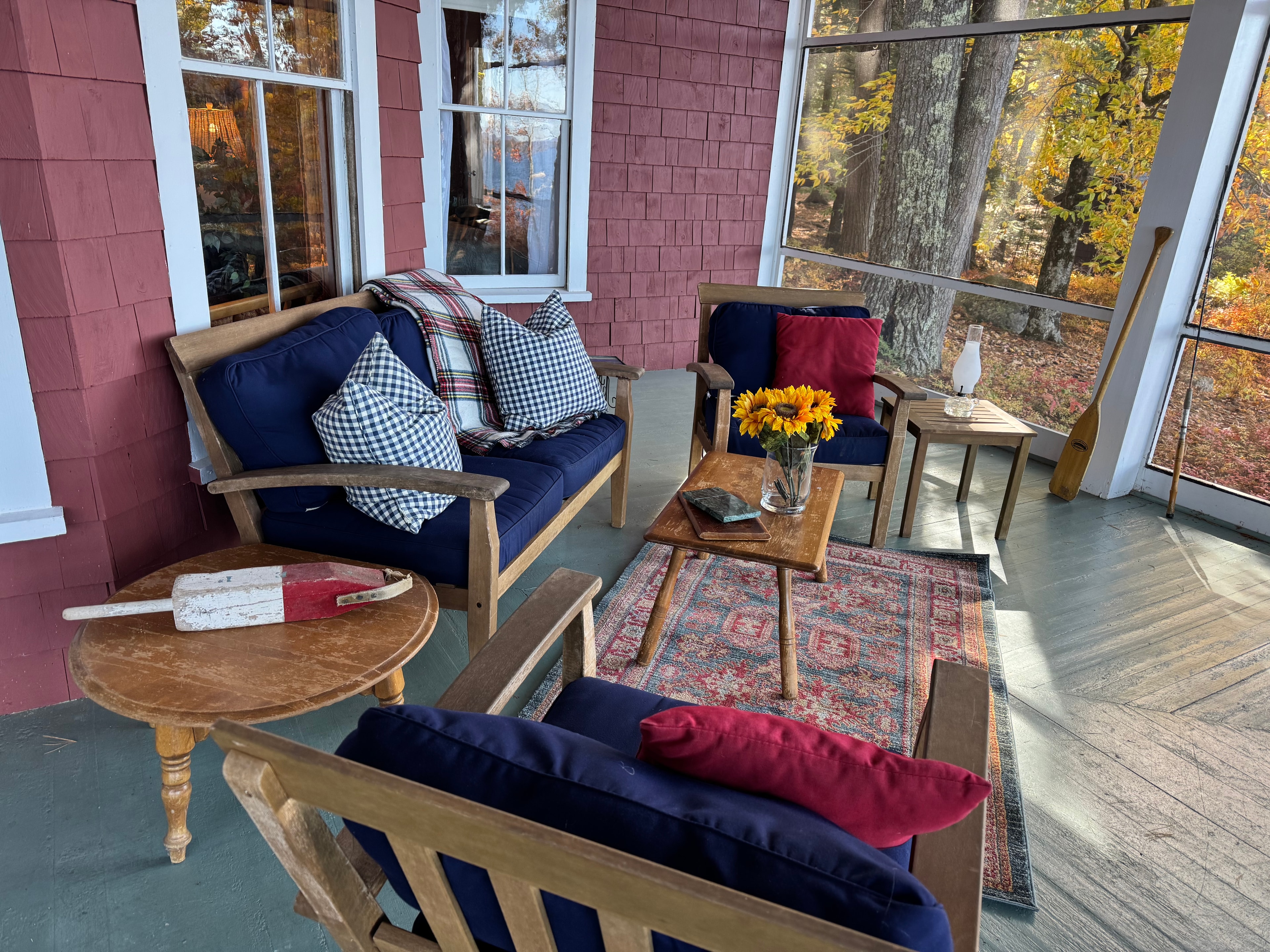 Lake camp porch after staging — cozy porch seating with autumn view