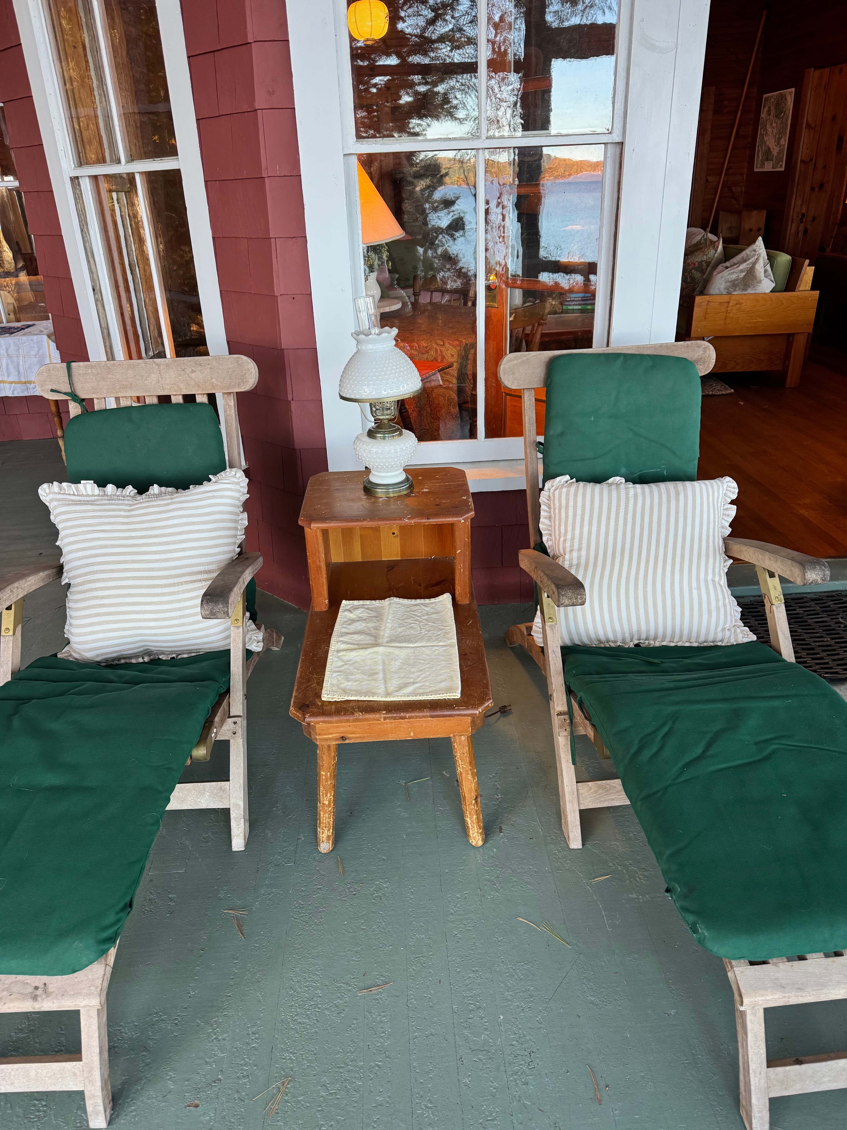 Lake camp porch after staging — Adirondack chairs by the lake